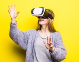 Teenage girl with virtual reality headset on yellow background